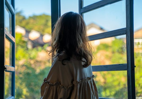 Mulher pensativa olhando pela janela